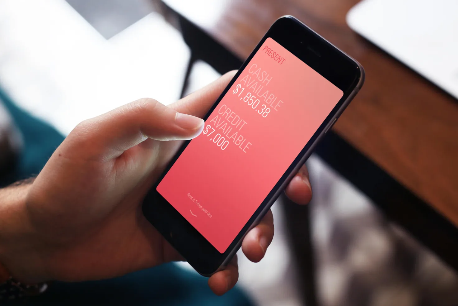 Hand holding a phone showing a cash balance card interaction