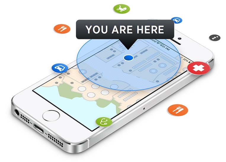 An iPhone showing an indoor floor map with a You Are Here marker on a blue location dot, surrounded by floating point-of-interest icons for dining, medical, parking, and information